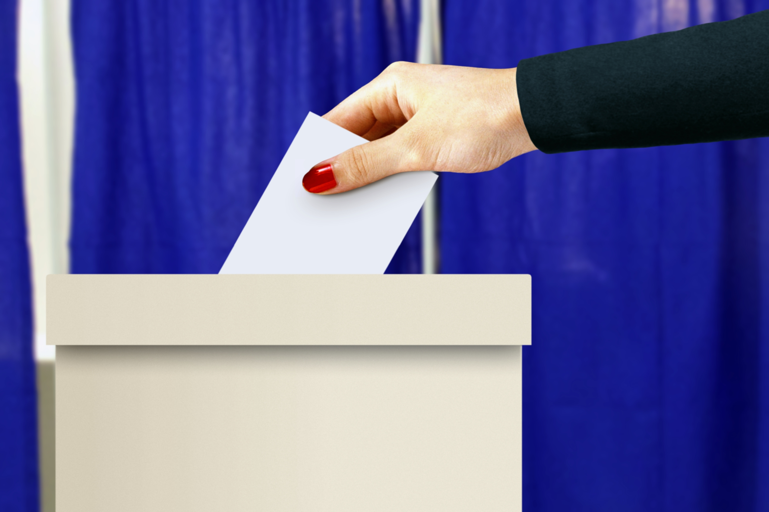 Ballot box with women hand casting a vote