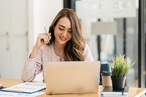 Woman at desk working on laptop computer