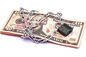 A photograph of a pile of money padlocked with a chain.